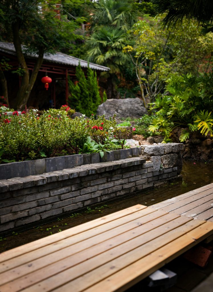 a wooden bench sitting next to a brick wall